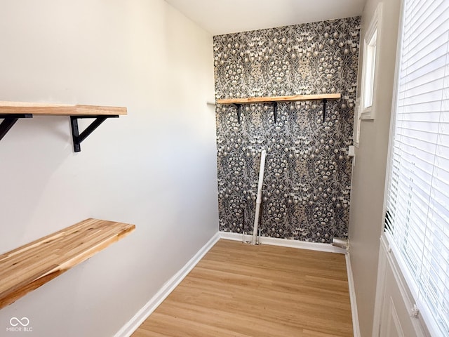 walk in closet with light wood-style flooring