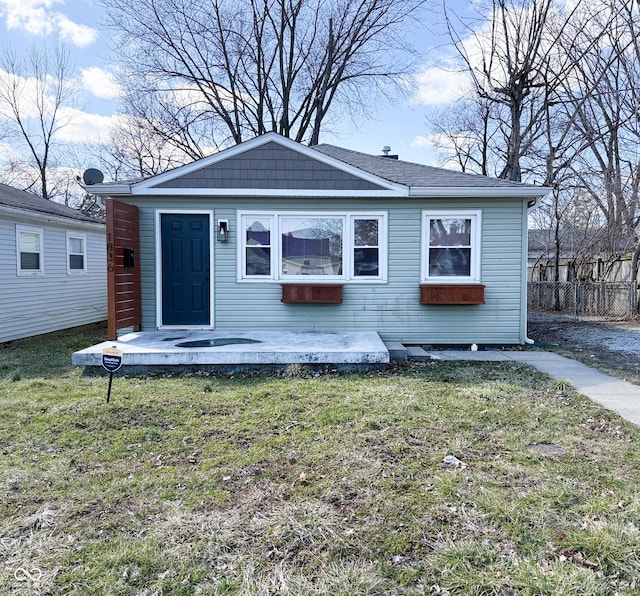 view of front of house with a front lawn and fence