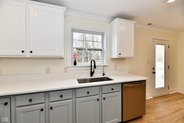 kitchen with visible vents, gray cabinets, a sink, stainless steel dishwasher, and crown molding