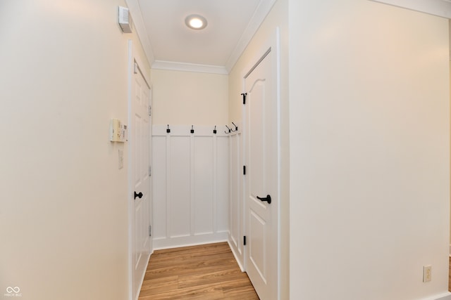 doorway featuring visible vents, light wood-style flooring, and ornamental molding