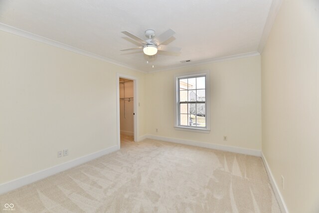 empty room featuring crown molding, baseboards, and light carpet