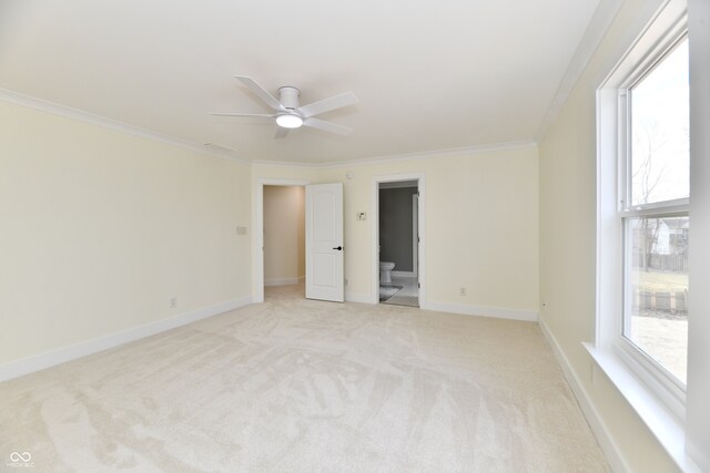 unfurnished bedroom featuring light carpet, multiple windows, crown molding, and baseboards