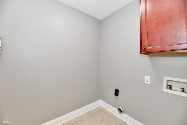 clothes washing area with light tile patterned floors, cabinet space, baseboards, and washer hookup