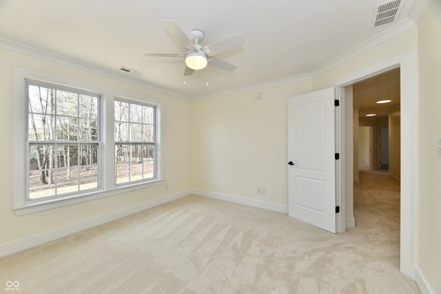 empty room with visible vents, baseboards, carpet, and crown molding