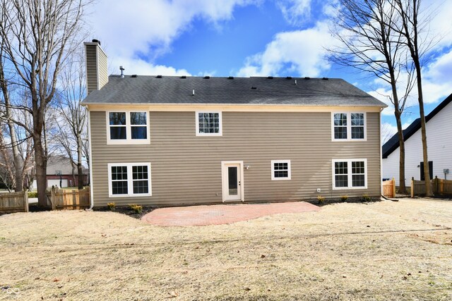 rear view of property with a patio, a chimney, and fence