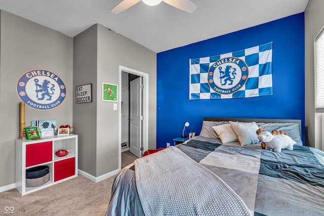 carpeted bedroom with ceiling fan and baseboards