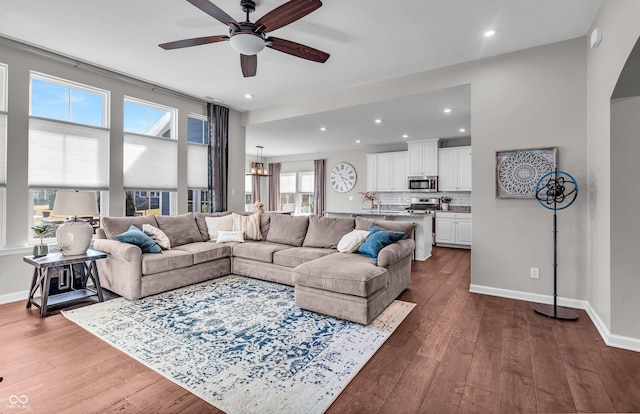 living room with recessed lighting, dark wood-style flooring, and baseboards