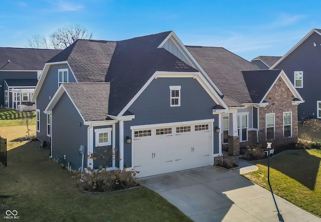 traditional-style house featuring a front yard, concrete driveway, roof with shingles, and an attached garage