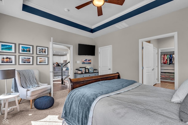 bedroom with visible vents, a tray ceiling, ceiling fan, and ornamental molding