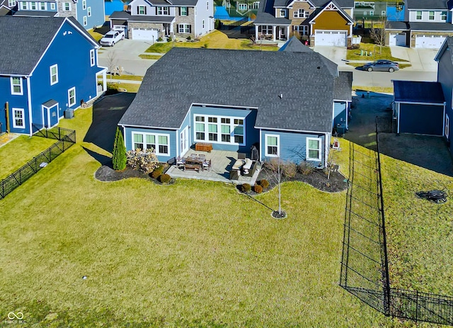 rear view of property with roof with shingles, a yard, a patio area, a residential view, and a fenced backyard