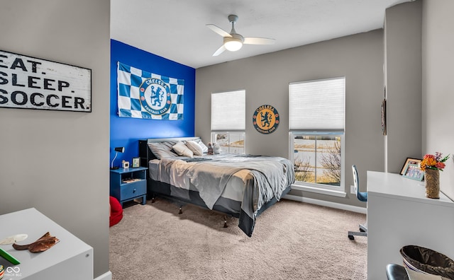 carpeted bedroom with ceiling fan and baseboards