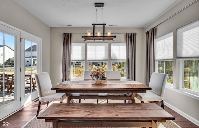 dining area featuring baseboards, dark wood finished floors, visible vents, and an inviting chandelier