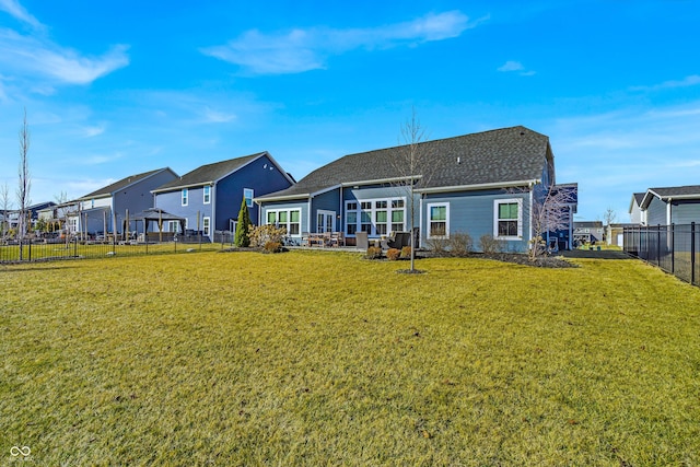 rear view of property with a yard and fence