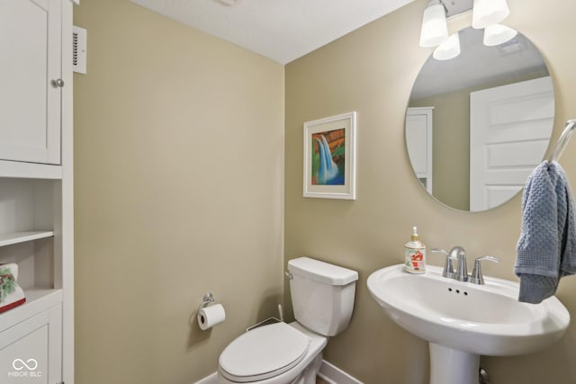 bathroom with toilet, baseboards, and a sink