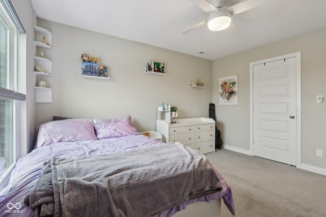 bedroom featuring light carpet, visible vents, a ceiling fan, and baseboards