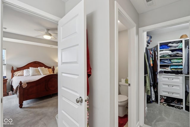 bathroom featuring a spacious closet, visible vents, toilet, and ceiling fan