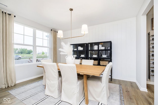 dining space with baseboards, visible vents, and light wood-style floors