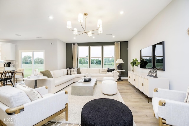 living room with recessed lighting, an inviting chandelier, and light wood-style floors