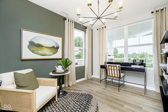 office featuring a chandelier, light wood-style flooring, visible vents, and baseboards