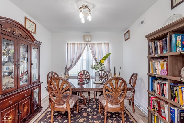 dining area with baseboards, wood finished floors, and visible vents