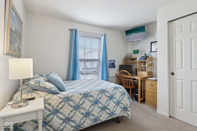 bedroom with light colored carpet and a textured ceiling