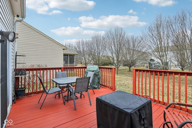 deck with outdoor dining area and a grill