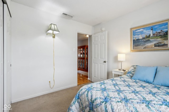 bedroom with carpet floors, visible vents, and baseboards