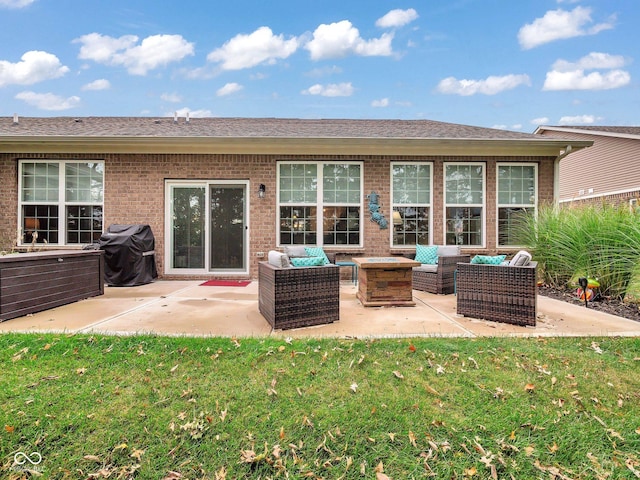 back of house featuring brick siding, a yard, an outdoor living space with a fire pit, and a patio