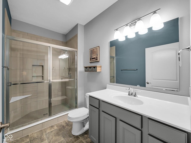 full bath featuring a stall shower, vanity, and toilet