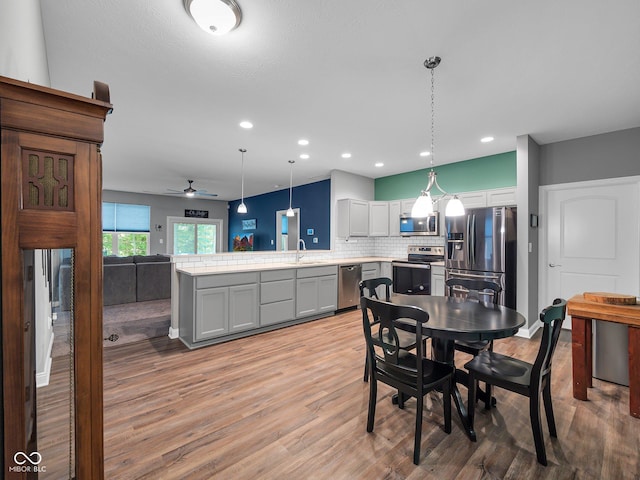 dining room featuring light wood finished floors, ceiling fan, and recessed lighting