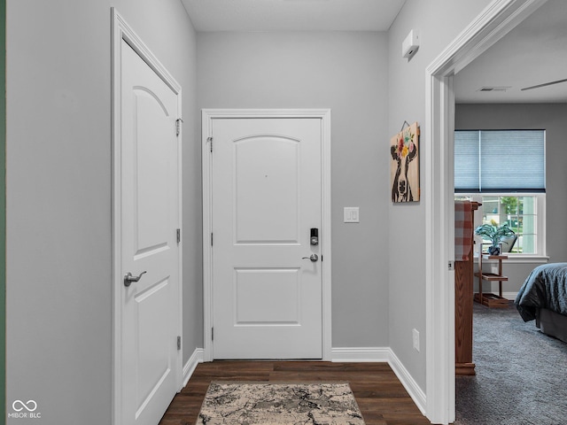 foyer with dark wood-type flooring and baseboards