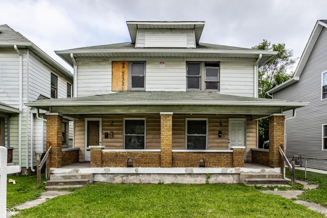 traditional style home with a porch, a shingled roof, and brick siding