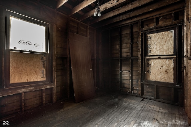 misc room with beam ceiling, wood walls, and hardwood / wood-style flooring