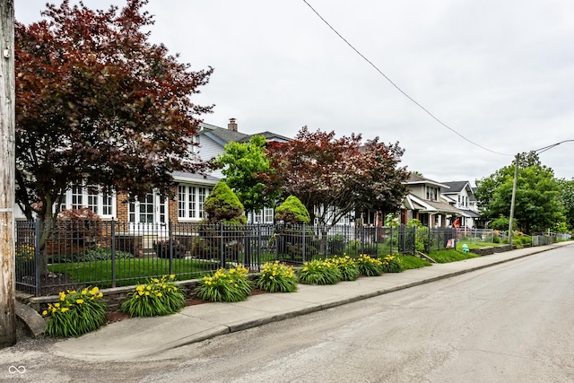 obstructed view of property with a fenced front yard and brick siding