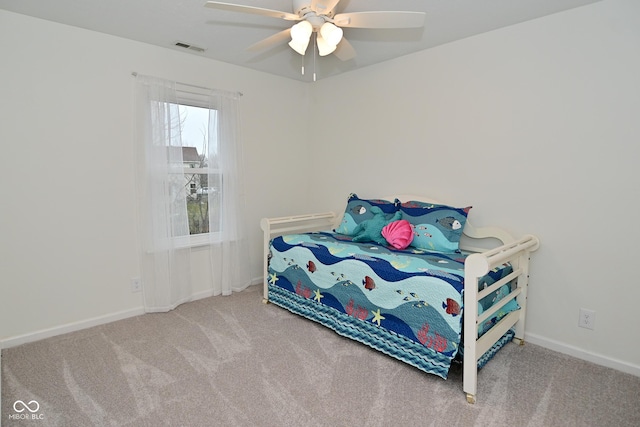 carpeted bedroom with a ceiling fan, visible vents, and baseboards