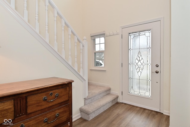 entryway featuring light wood-type flooring, stairs, and baseboards