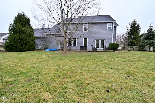 rear view of property with a yard, french doors, and fence