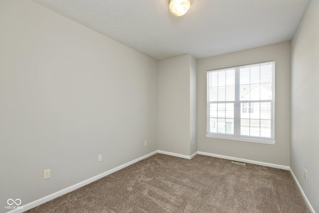 carpeted spare room featuring baseboards