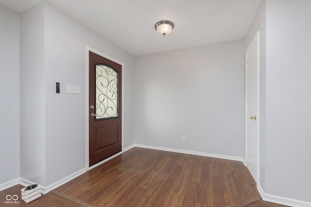 foyer featuring dark wood-type flooring and baseboards