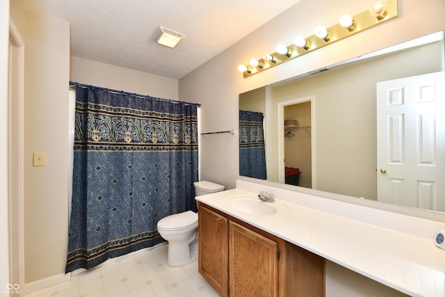 bathroom with tile patterned floors, visible vents, toilet, a textured ceiling, and vanity