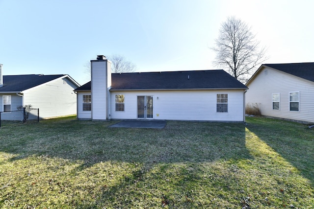 back of property featuring a patio, fence, a shingled roof, a chimney, and a lawn