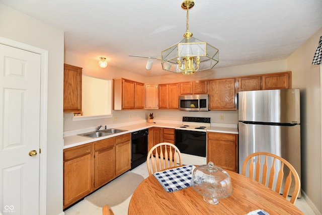 kitchen with pendant lighting, a sink, stainless steel appliances, light countertops, and a chandelier