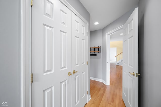 corridor featuring light wood finished floors, baseboards, and recessed lighting