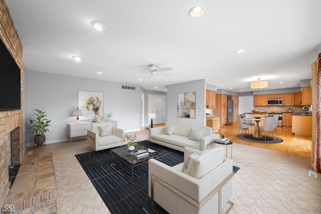 living room with recessed lighting, visible vents, a ceiling fan, a brick fireplace, and baseboards