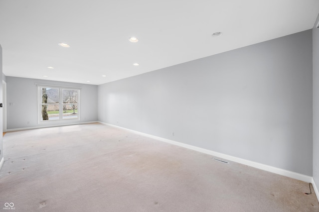 unfurnished room featuring recessed lighting, light carpet, and baseboards