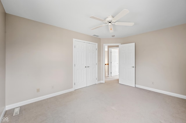 unfurnished bedroom featuring light colored carpet, a closet, visible vents, and baseboards