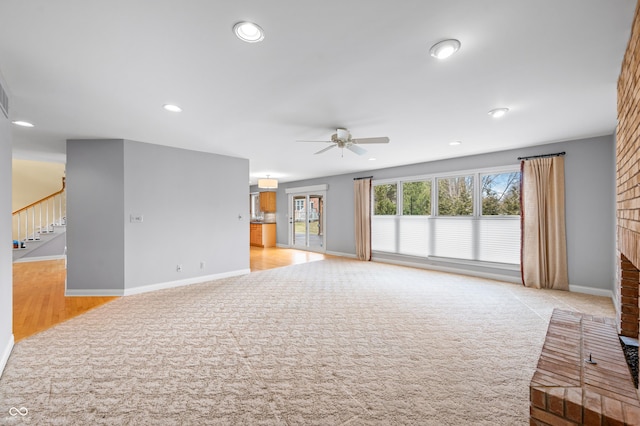 unfurnished living room featuring stairs, recessed lighting, a ceiling fan, and light colored carpet