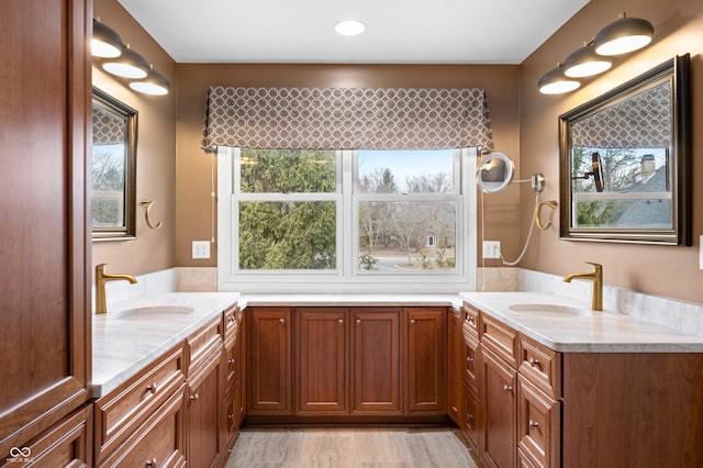 full bathroom with a wealth of natural light, two vanities, and a sink