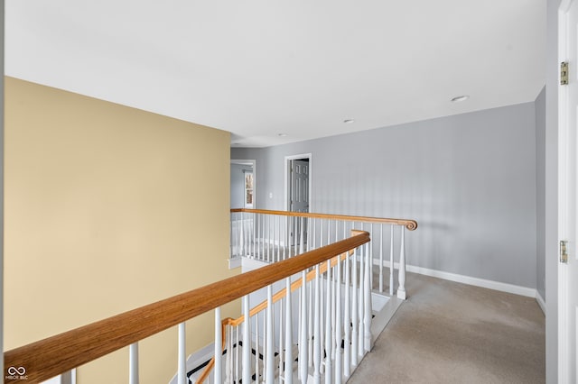 hall featuring carpet, an upstairs landing, and baseboards