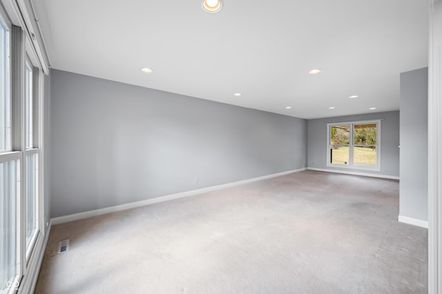 spare room with carpet floors, recessed lighting, visible vents, and baseboards